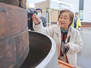 慈善釜に募金を入れる市民＝長岡市寺島町