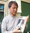 　大切に保管している湯川秀樹氏の本を持つ芝上基成さん＝３月、茨城県つくば市