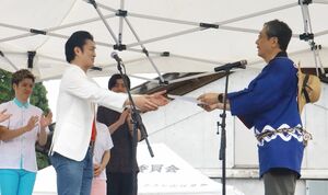 関川村ふるさと大使の委嘱を受ける山口コンボイさん(左)=関川村上関