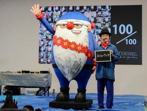 大阪・関西万博の会場で制作した「みらいサンタ」と谷口智則さん=9月、大阪市此花区の夢洲