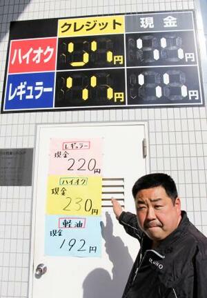 　ガソリンスタンド備え付けの看板では１９９円までしか表示できず、急きょ紙に手書きした価格を示す三枝直樹店長＝１６日午後、東京都足立区