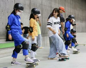 韓国選手からスケボーの手ほどきを受け、交流を深めた小学生=村上市瀬波温泉3