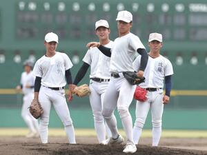 ノックを受ける中越の投手陣。右から遠藤快斗、石山愛輝、雨木天空、高野塁=兵庫県西宮市