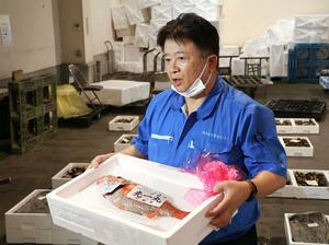 県産高規格ノドグロの「美宝」を競り落とした岩船港鮮魚センターの安宅謙社長=7月19日、村上市岩船港町