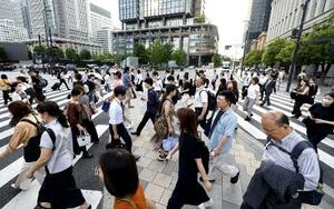 東京・丸の内のオフィス街を行き交う人たち=7月