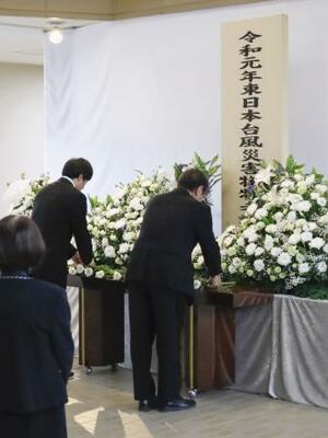 台風19号上陸から6年となり、宮城県丸森町に設けられた献花台に花を供える参列者=12日午前
