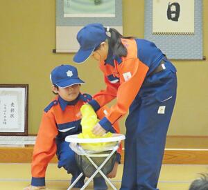 集落の自主防災組織の訓練で、簡易トイレの設置方法を伝える笹沢少年消防クラブのメンバー＝２０２５年１０月、津南町外丸