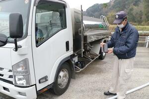 
桜ケ丘中継ポンプ場で給水車に水を積む前に水質を調べる上下水道局の職員＝宮崎市
