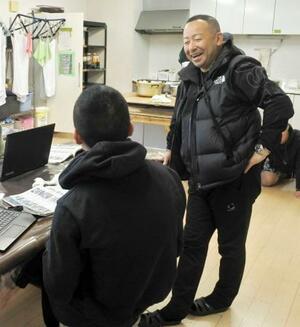 　更生保護施設で、将来の進路について少年と話をする工藤良さん（右）＝福岡県田川市