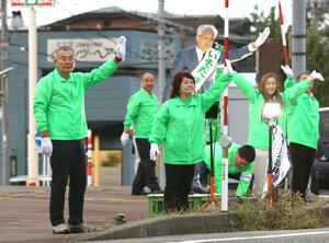 選挙戦最終日、市議と共に手を振って支持を訴える磯田達伸氏=10月5日、長岡市