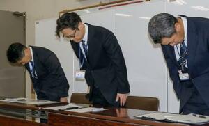 　記者会見で頭を下げる大阪市教育委員会の乗京慎二第３教育ブロック担当部長（中央）ら＝２０日午後、市役所