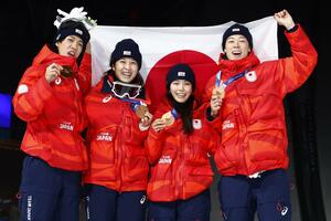 混合団体で銅メダルを獲得し、笑顔で日の丸を掲げる（左から）二階堂蓮、丸山希、高梨沙羅、小林陵侑＝プレダッツォ（共同）