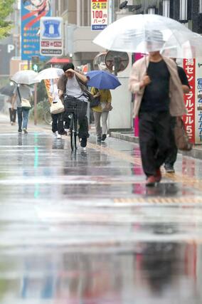 県内に久々の雨 降りしきる雨の中を歩く人たち=5日、新潟市中央区東大通1