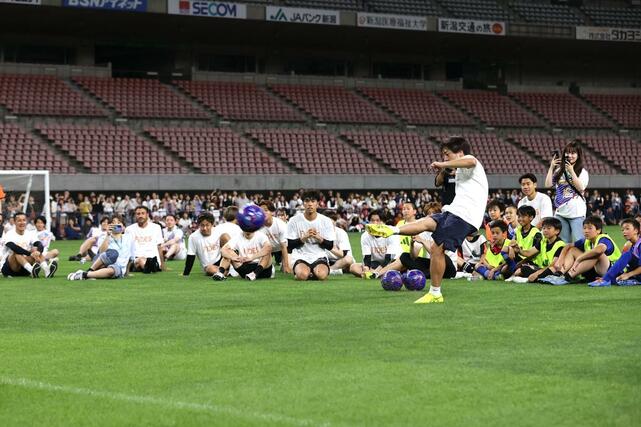 子どもたちに精度の高いキックを披露する元アルビレックス新潟の高木善朗＝６月１４日、デンカビッグスワン