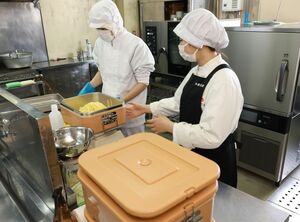 スクールランチを調理する地域おこし協力隊の人たち＝粟島浦村