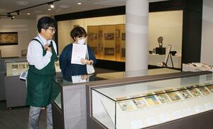 源氏物語を描いた色紙などが並ぶ新発田市歴史図書館の企画展=新発田市中央町4