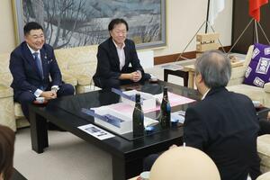 海底熟成酒の完成を花角英世知事に報告するマルソーグループの渡邉雅之・最高経営責任者ら＝７月、県庁