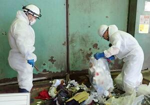 水銀の基準値超過を受け、ごみの展開検査を行う佐渡市職員=佐渡市中原(佐渡市提供)