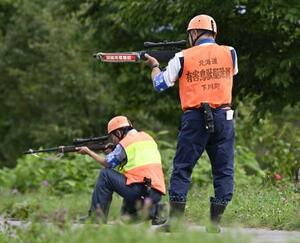 研修会で、町から緊急銃猟の委託を受け証票となる腕章を着けて発砲までの工程を確認するハンター=8月、北海道下川町