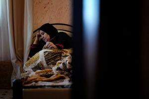 自宅で横たわるアファフ・アブアリアさん=10月27日、ヨルダン川西岸ムガイヤ(共同)