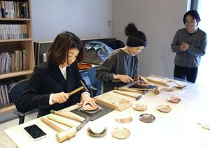 鎚起銅器を体験する台湾からの観光客。燕三条地域のものづくり文化を体感していた＝燕市の玉川堂