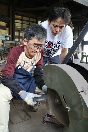 「燕三条　工場の祭典」参加施設の近藤製作所でフライパン作りを体験する来場者（左）＝１０月３日、三条市猪子場新田