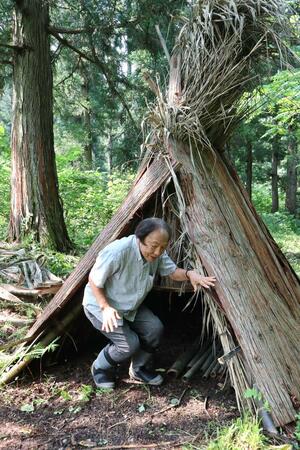 旧石器時代と同様に杉皮や竹で作った住居について説明する関野吉晴さん=村上市山熊田