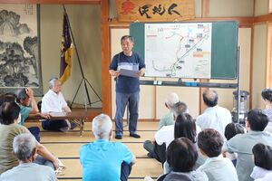 町内の備蓄品の場所や危険箇所を示した防災マップを住民に説明する菊入毅さん=柏崎市西山町下山田