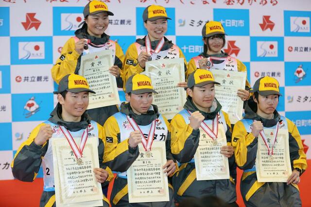男女で表彰台に上がり喜ぶ十日町のリレーメンバー＝８日、十日町市の吉田クロスカントリー競技場