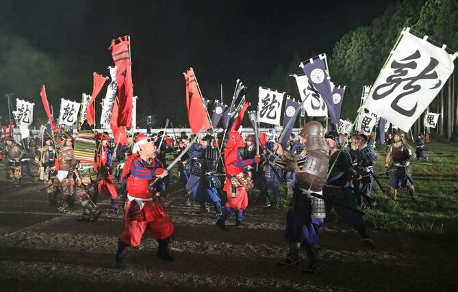 上杉、武田両軍勢が入り乱れた合戦シーンを熱演する市民ら＝２３日、上越市の春日山城史跡広場