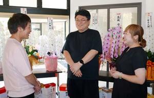 旅館「はまづる」の営業再開セレモニーを終え、和倉温泉の関係者と談笑する高城一博さん(中央)=2日午後、石川県七尾市
