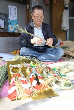 丁寧に縄をなう「ささかみしめ飾り部会」の五十嵐繁部会長=阿賀野市笹神地区