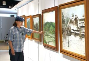古い町並みや風景などを描いた作品を紹介する早津剛さん=見附市昭和町2