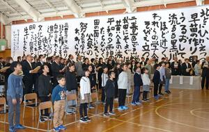 校歌の巨大書の前で歌声を響かせる児童ら=長岡市大積町1
