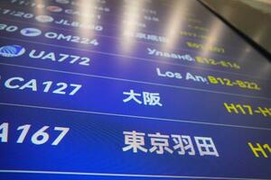 中国が日本への渡航自粛を呼びかけてから約1カ月となる北京首都国際空港で、羽田や大阪行きなどの便名が並ぶ出発表示板=13日、北京(共同)