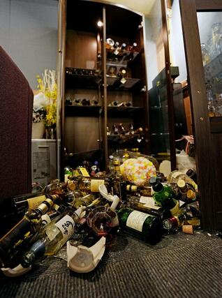 強い地震があった青森県八戸市のスナックで散乱した酒瓶。女性店主は「（瓶が）とび出さないように対策はしていたのに…」とため息をついた＝９日午後０時１２分