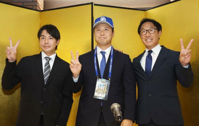 会見を終え、記念撮影する牧野憲伸（中央）＝新潟市中央区