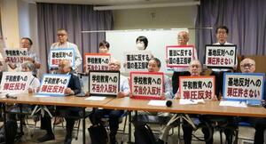 記者会見でプラカードを掲げる被爆者団体などの代表者ら=8日午後、長崎市