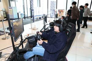 戦闘やレースのゲームを体験する来場者=31日、新潟市中央区万代3