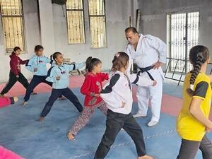 　空手教室で練習する少女たち。奥で教えるのはハッサン・ライさん＝２０２５年１２月、ガザ市（共同）