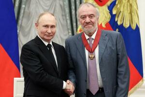 モスクワのクレムリンで、指揮者のゲルギエフ氏(右)に勲章を授与して握手するロシアのプーチン大統領=2024年5月(タス=共同)