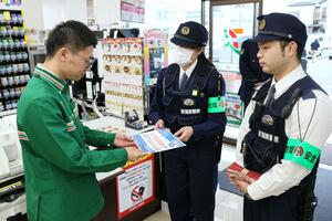 担当店舗に交番名の入った紹介プレートを手渡す警察官＝新潟市東区山木戸７
