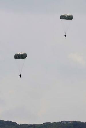 沖縄県の米軍嘉手納基地で、パラシュート降下訓練をする兵士=27日午前