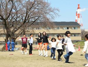 胎内ディアーズのチアリーダーと選手、子どもたちが一緒にチアダンスを踊ったクラレ桜まつり=4月6日、胎内市協和町