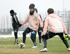 寒さが厳しい中、今季最終戦に向けて調整するMF長谷川元希(中央)=聖籠町