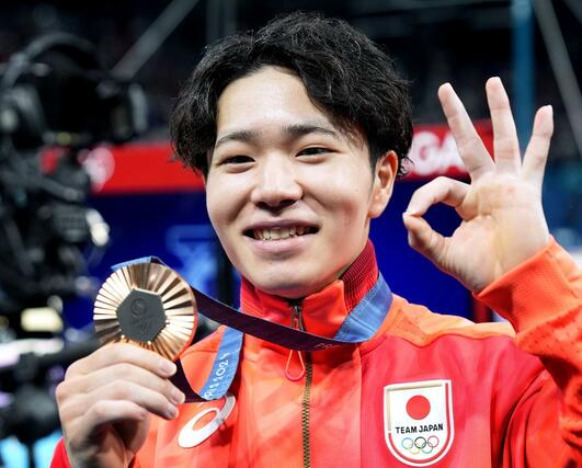 男子種目別平行棒で銅メダルを獲得し、笑顔でポーズをとる岡慎之助＝パリ（共同）