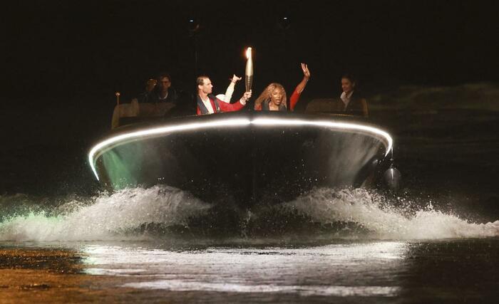 セーヌ川で行われたパリ五輪の開会式で聖火を運ぶラファエル・ナダル（左）とセリーナ・ウィリアムズ＝７月２６日、パリ（ロイター＝共同）