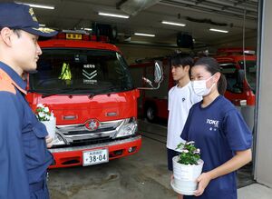 東頸消防署の署員に花を手渡して感謝を伝える東頸中の生徒=上越市安塚区