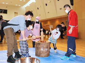 きねを振るい餅つきを楽しむ家族連れ=刈羽村刈羽