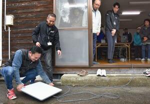 衛星インターネットサービス「スターリンク」を設置する住民ら=2日午前、石川県かほく市